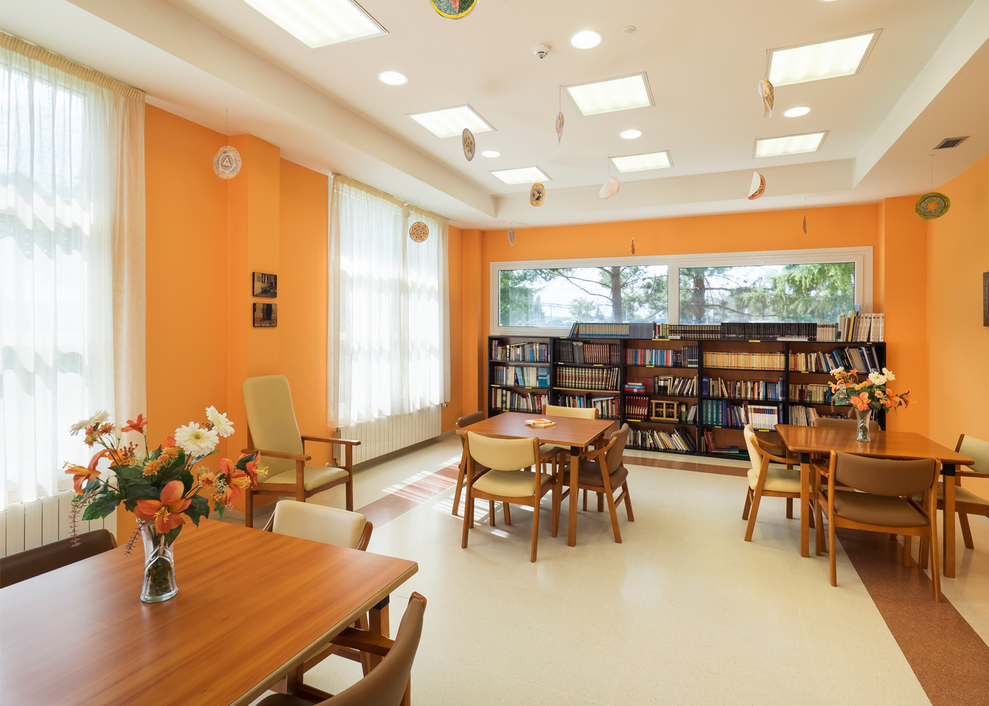 Biblioteca del centro residencial Baño Salud con varias sillas, mesas y librerías