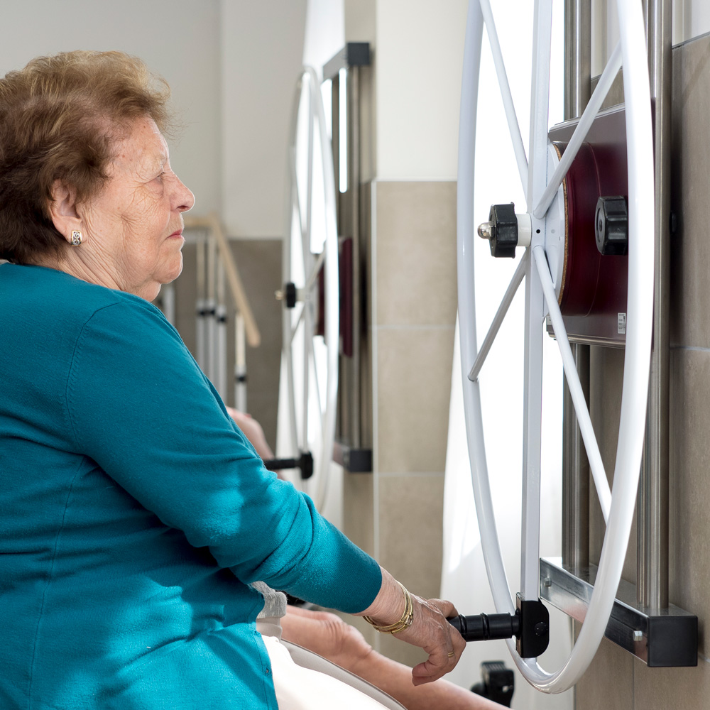 Una residente realizando una sesión de actividad física en la sala de rehabilitación